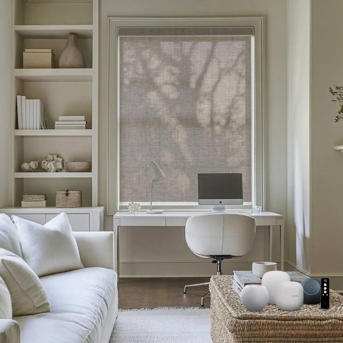 Home office with a woven light-filtering motorized shade partially lowered, casting a tree-branch shadow pattern over a desk and computer